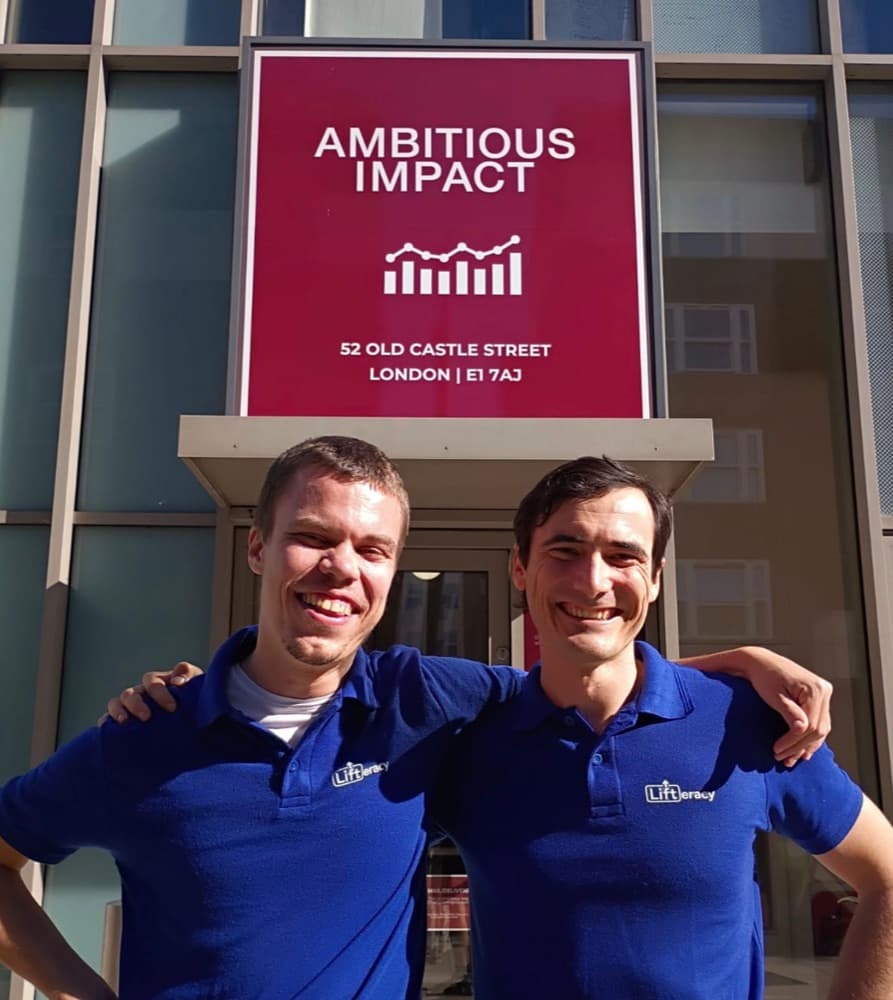 Tom Delaney (left) and David Nelson (right) in LIFTeracy shirts outside Ambitious Impact in London